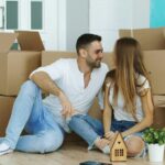 Newcomers moving into their first rental home in New Zealand, sitting among moving boxes