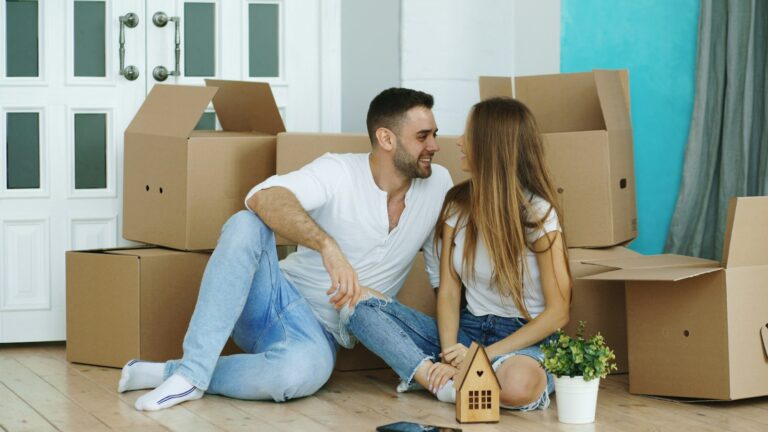 Newcomers moving into their first rental home in New Zealand, sitting among moving boxes