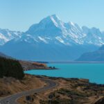 A road in New Zealand winding toward Lake Pukaki and snow-capped mountains