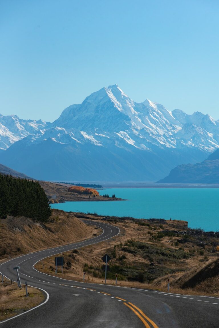 A road in New Zealand winding toward Lake Pukaki and snow-capped mountains
