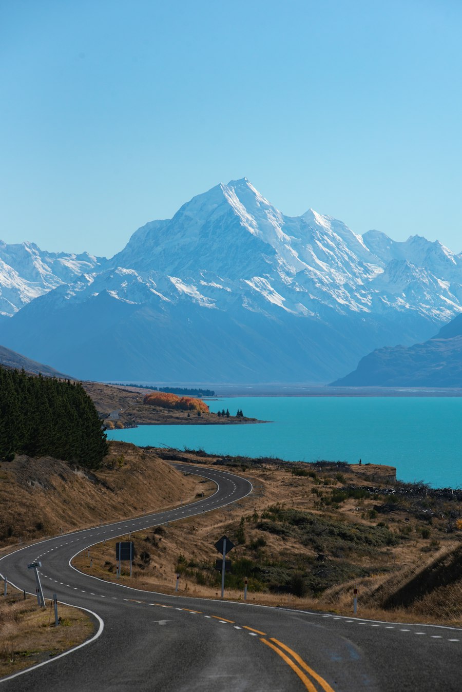 A road in New Zealand winding toward Lake Pukaki and snow-capped mountains